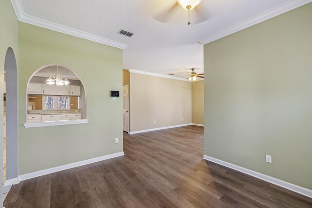 unfurnished room featuring visible vents, baseboards, dark wood finished floors, ornamental molding, and ceiling fan with notable chandelier