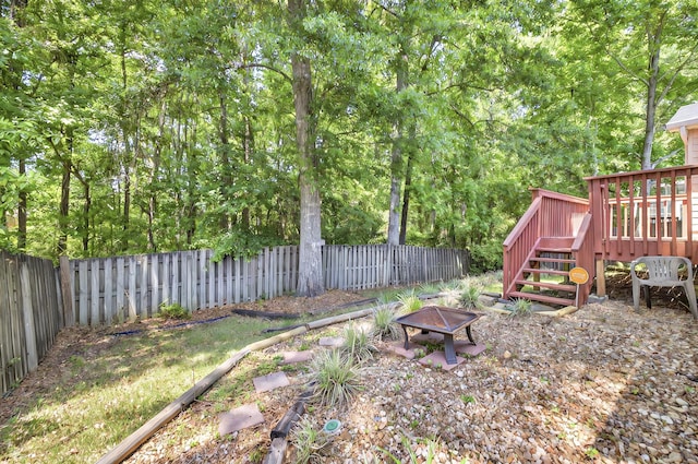 8504 Hannary Cir, Tallahassee, FL 32312 - view of yard featuring a wooden deck, a fenced backyard, and an outdoor fire pit