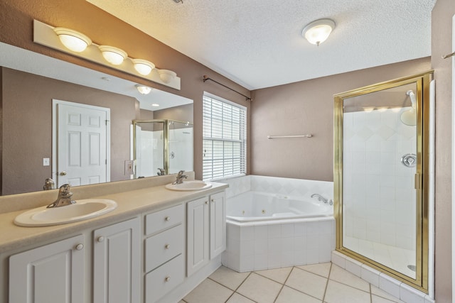 full bath featuring a jetted tub, tile patterned flooring, a sink, and a shower stall