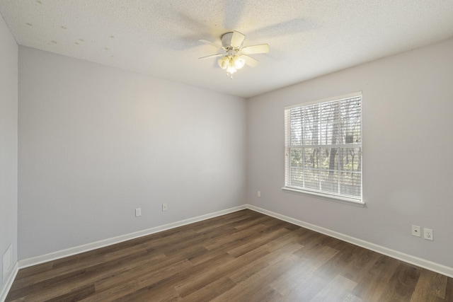 spare room with ceiling fan, a textured ceiling, baseboards, and dark wood-style flooring