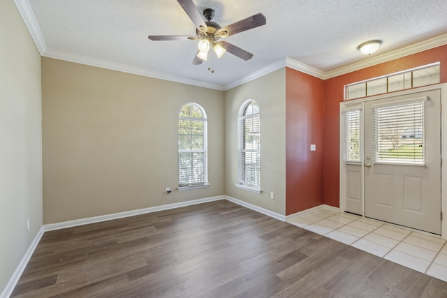 foyer with a textured ceiling, wood finished floors, and crown molding