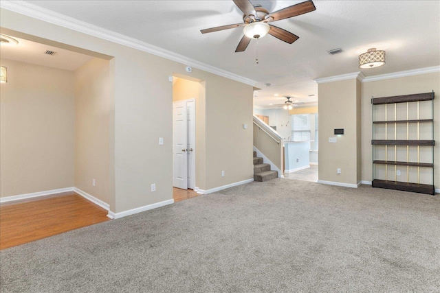 unfurnished room with ceiling fan, light colored carpet, ornamental molding, and a textured ceiling