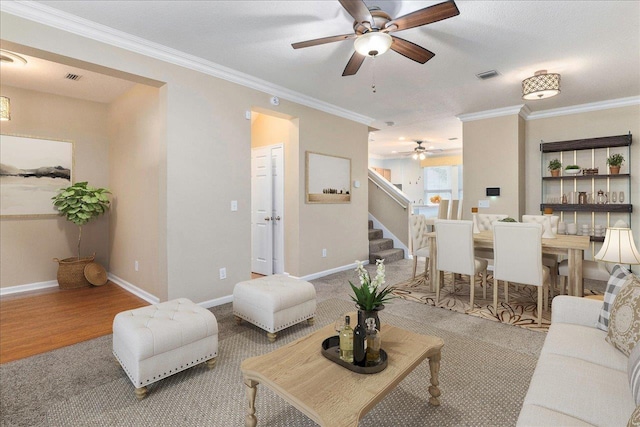 living room with a textured ceiling, light hardwood / wood-style flooring, ceiling fan, and crown molding