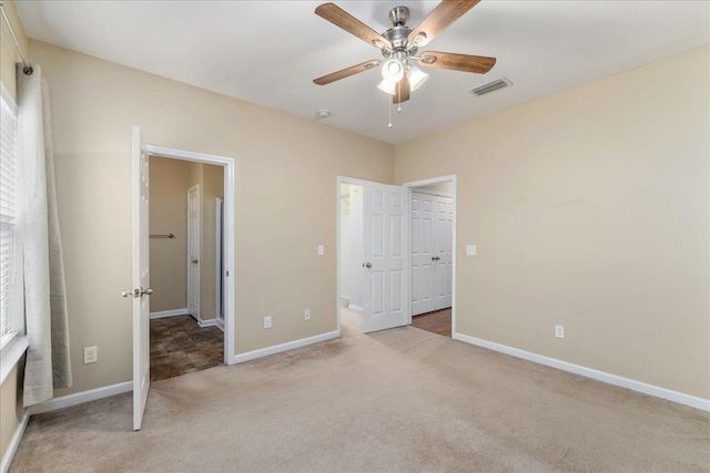 unfurnished bedroom featuring ceiling fan and light colored carpet