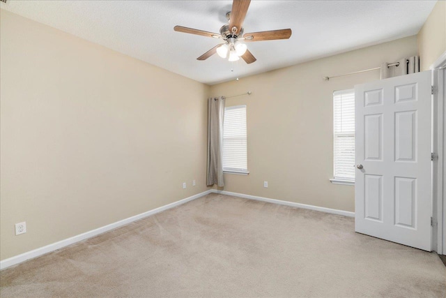 empty room with ceiling fan and light colored carpet