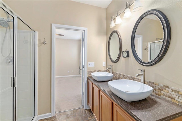 bathroom featuring vanity, backsplash, and walk in shower