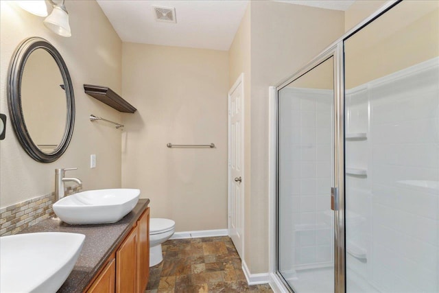 bathroom featuring vanity, toilet, and walk in shower