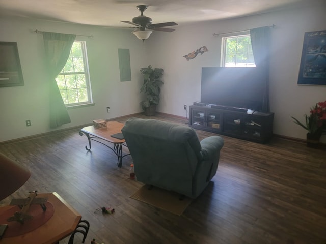 living room featuring dark wood-type flooring and ceiling fan