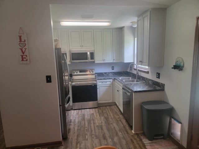 kitchen featuring white cabinets, appliances with stainless steel finishes, sink, and dark hardwood / wood-style floors