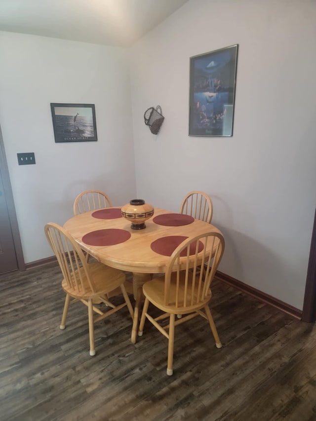 dining room with dark hardwood / wood-style flooring and vaulted ceiling