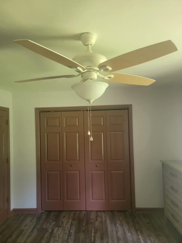 unfurnished bedroom with dark hardwood / wood-style flooring, ceiling fan, and a closet