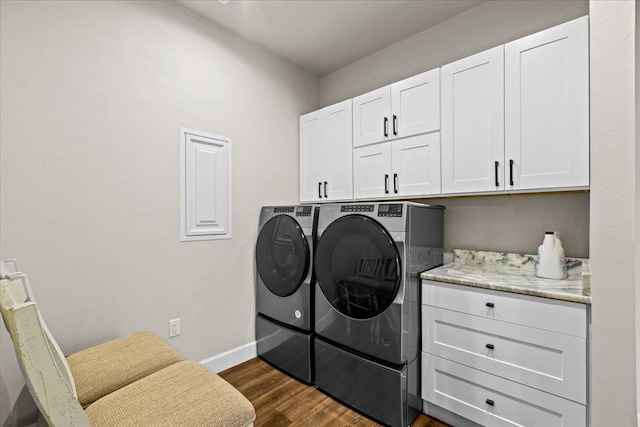 washroom featuring cabinets, dark hardwood / wood-style flooring, and washing machine and dryer