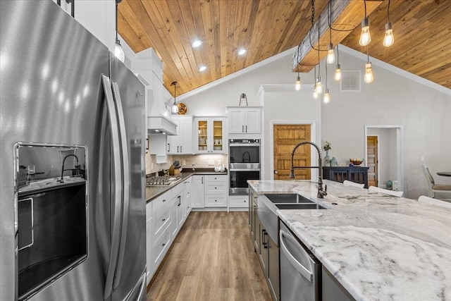 kitchen featuring white cabinetry, hanging light fixtures, and appliances with stainless steel finishes