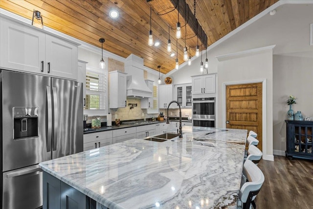 kitchen with appliances with stainless steel finishes, wood ceiling, a spacious island, white cabinets, and hanging light fixtures