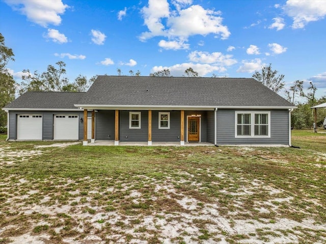 single story home featuring covered porch, a garage, and a front lawn