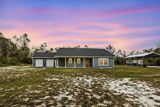 ranch-style house featuring a porch, a yard, and a garage