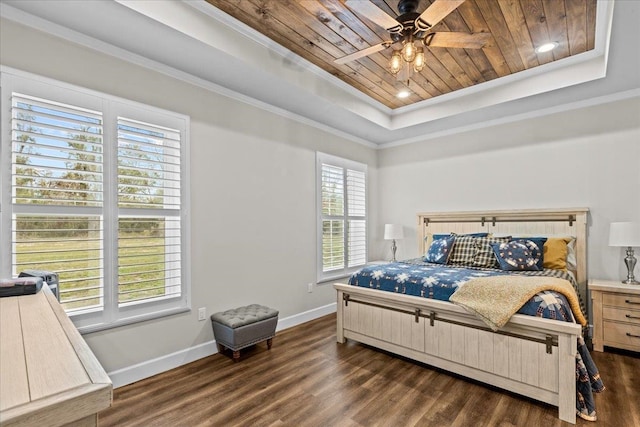 bedroom featuring dark hardwood / wood-style flooring, a tray ceiling, and multiple windows