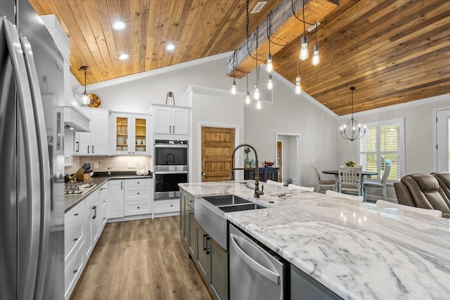 kitchen featuring pendant lighting, white cabinetry, stainless steel appliances, and high vaulted ceiling