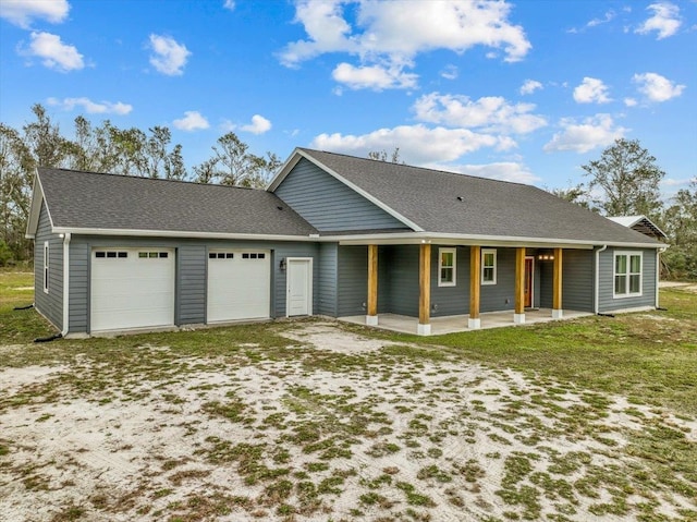 ranch-style house with covered porch, a front yard, and a garage