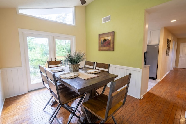 6611 Crooked Creek Rd, Tallahassee, FL 32311 - dining room with wainscoting, light wood-style floors, healthy amount of natural light, and high vaulted ceiling