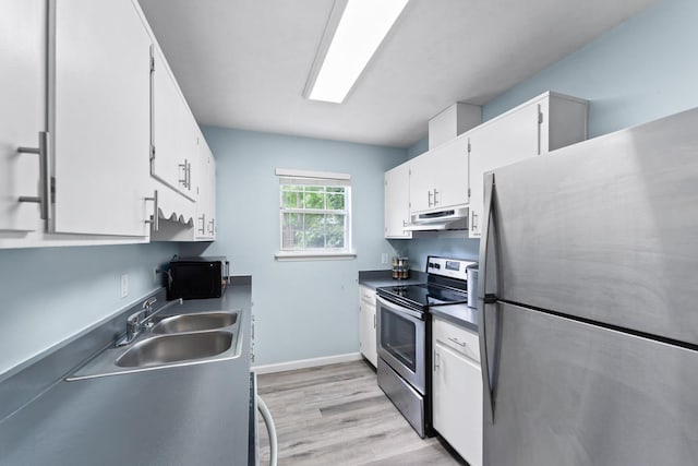 kitchen with white cabinets, appliances with stainless steel finishes, light hardwood / wood-style floors, and sink