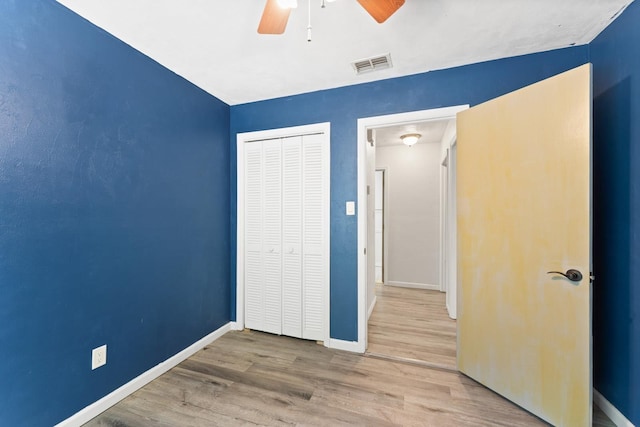 unfurnished bedroom featuring ceiling fan, a closet, and wood-type flooring