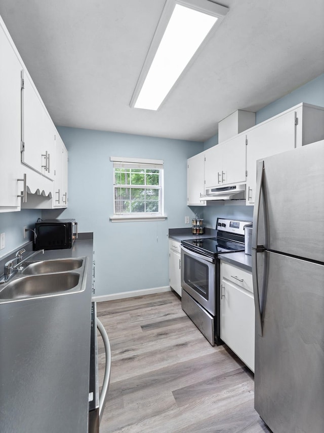 kitchen with white cabinets, appliances with stainless steel finishes, light wood-type flooring, and sink