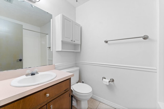 bathroom with toilet, vanity, and tile patterned floors