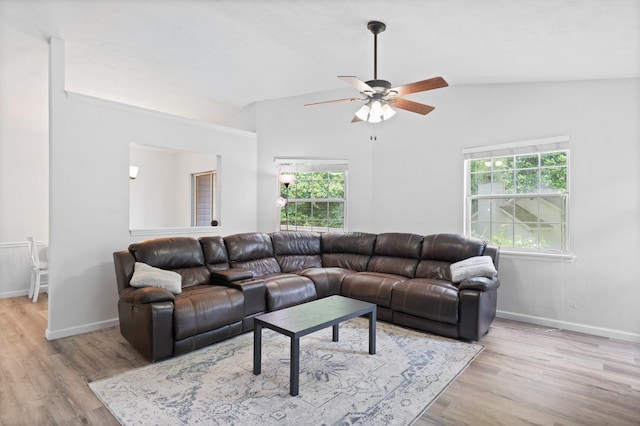 living room featuring ceiling fan, light hardwood / wood-style floors, and vaulted ceiling