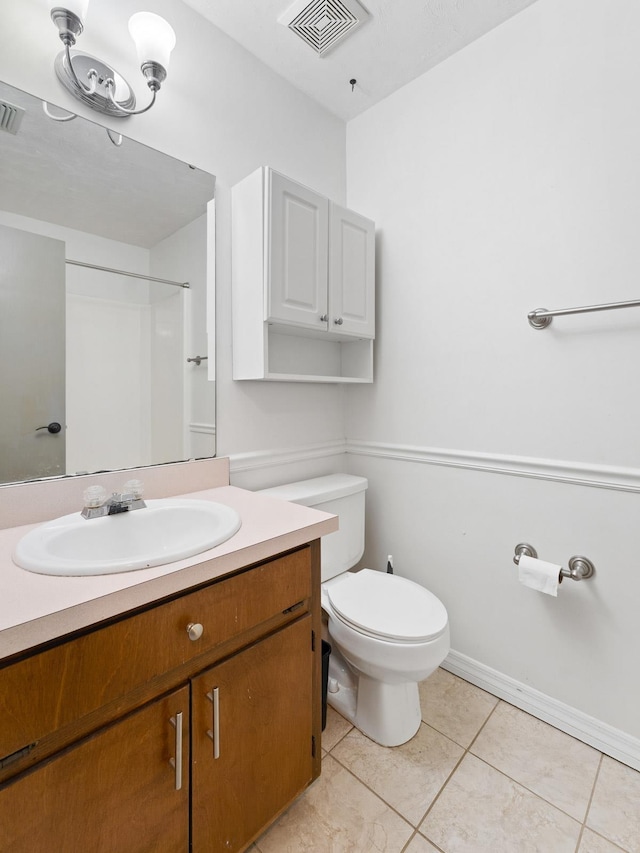 bathroom featuring toilet, a shower, vanity, and tile patterned floors