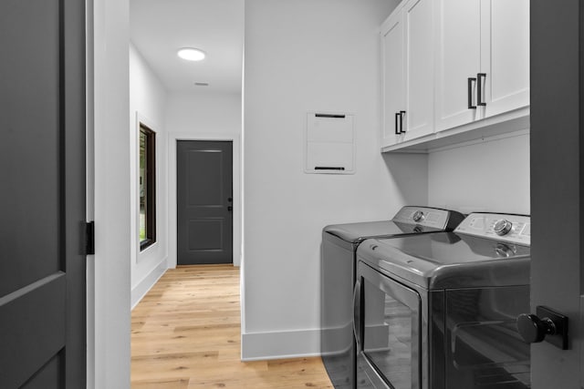 washroom with cabinets, separate washer and dryer, and light hardwood / wood-style flooring