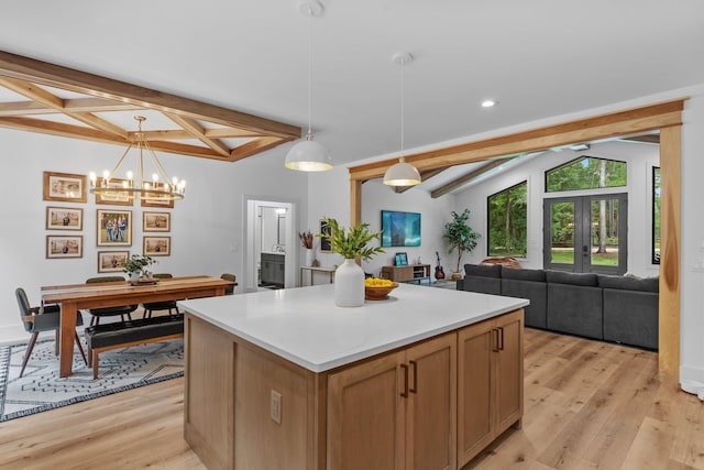 kitchen featuring a center island, beamed ceiling, light hardwood / wood-style floors, hanging light fixtures, and french doors