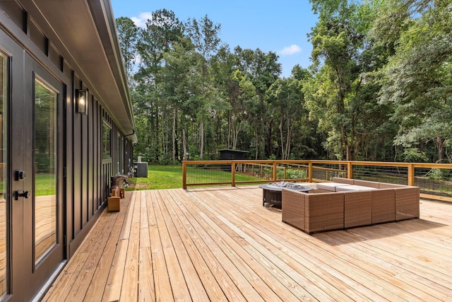 wooden deck featuring an outdoor living space with a fire pit