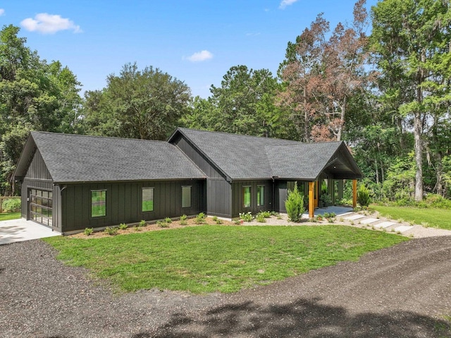 view of front of home with a garage, a front lawn, and a carport