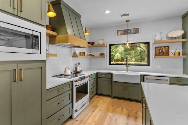 kitchen featuring light hardwood / wood-style flooring, custom range hood, sink, decorative backsplash, and white electric stove