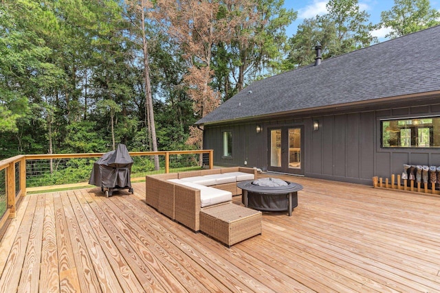 deck featuring an outdoor living space with a fire pit