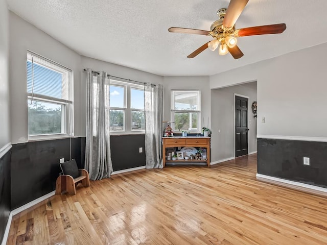 unfurnished room featuring ceiling fan, hardwood / wood-style floors, and a textured ceiling