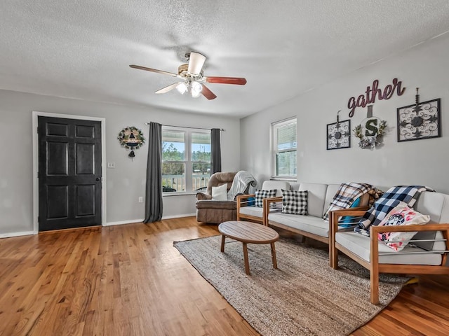 living room featuring hardwood / wood-style floors, a textured ceiling, and ceiling fan