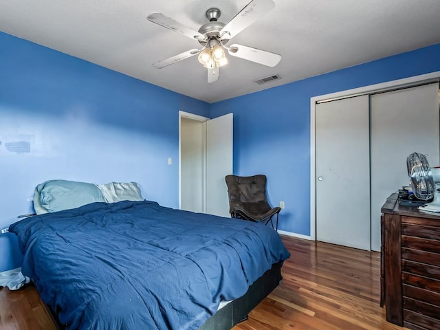 bedroom with ceiling fan, dark hardwood / wood-style floors, and a closet