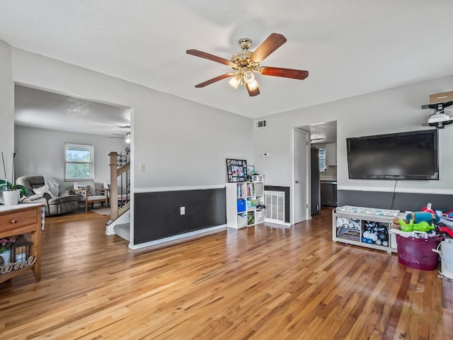 living room with hardwood / wood-style flooring and ceiling fan