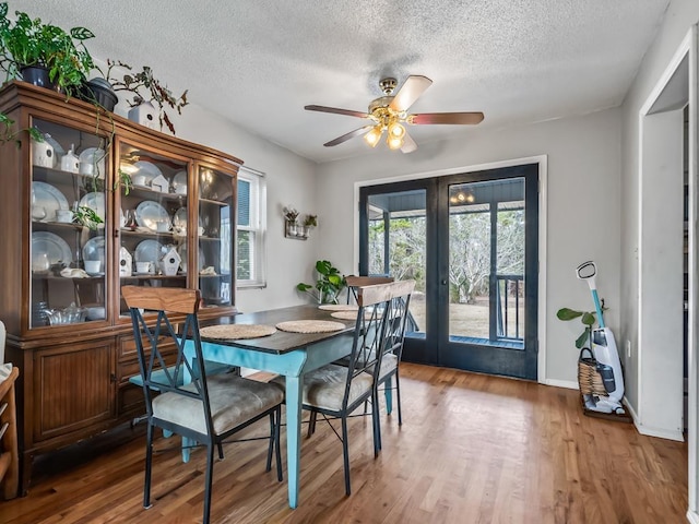 dining area featuring hardwood / wood-style flooring, plenty of natural light, ceiling fan, and french doors