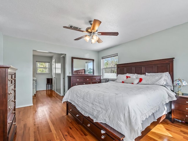 bedroom featuring ceiling fan, hardwood / wood-style floors, and a textured ceiling