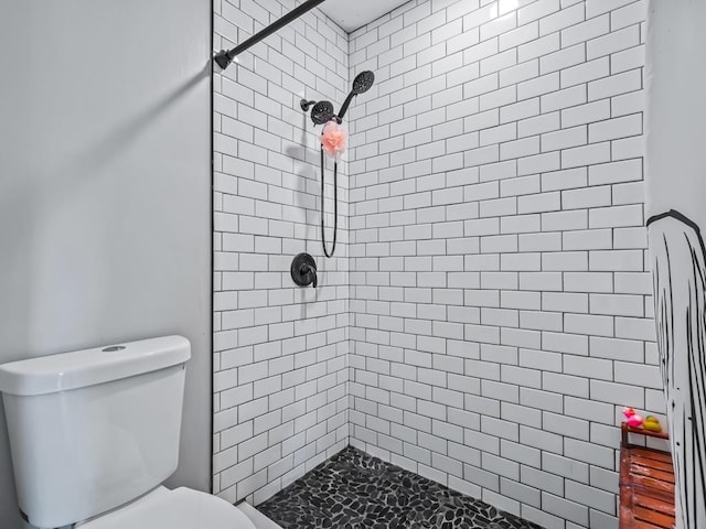 bathroom featuring tiled shower and toilet