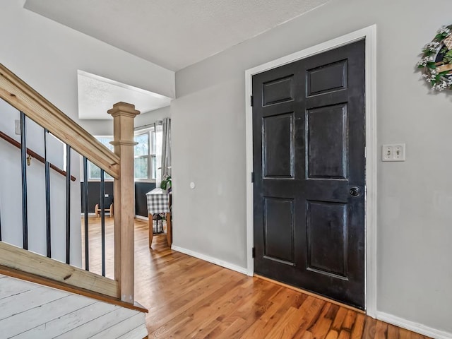 foyer entrance with wood-type flooring and decorative columns