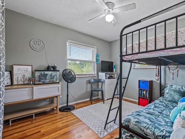 bedroom featuring wood-type flooring, ceiling fan, and a textured ceiling