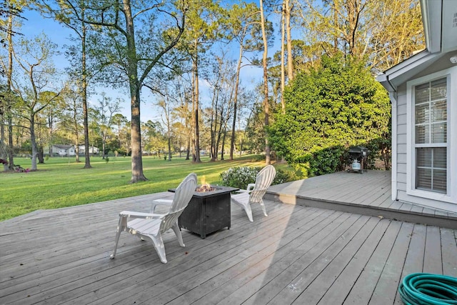 wooden deck featuring a lawn and an outdoor fire pit