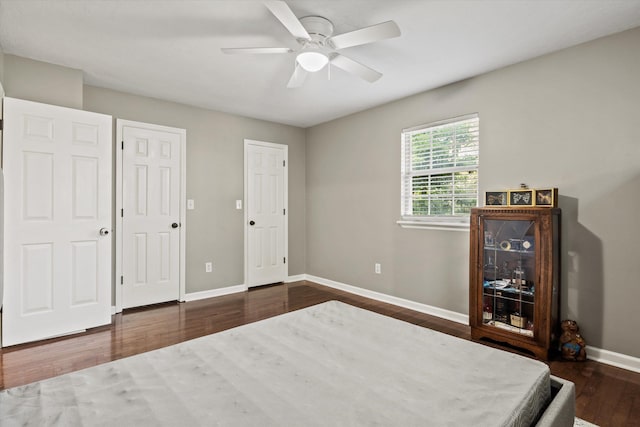 bedroom featuring a ceiling fan, baseboards, and dark wood-type flooring