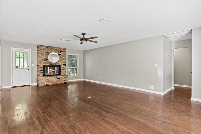 unfurnished living room featuring a fireplace, ceiling fan, visible vents, baseboards, and hardwood / wood-style flooring