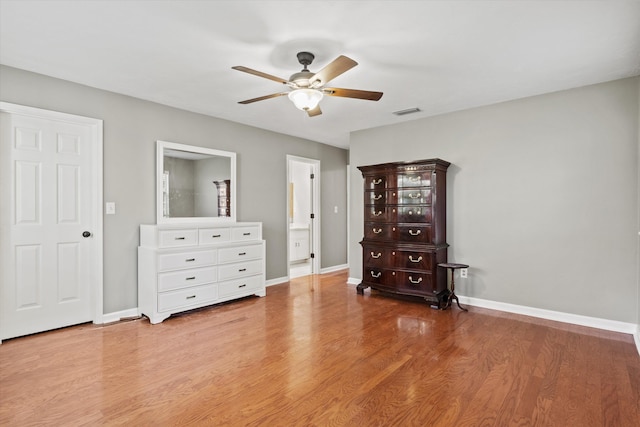bedroom featuring wood finished floors, visible vents, a ceiling fan, and baseboards