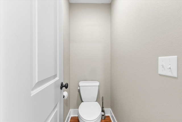 bathroom with toilet and hardwood / wood-style floors